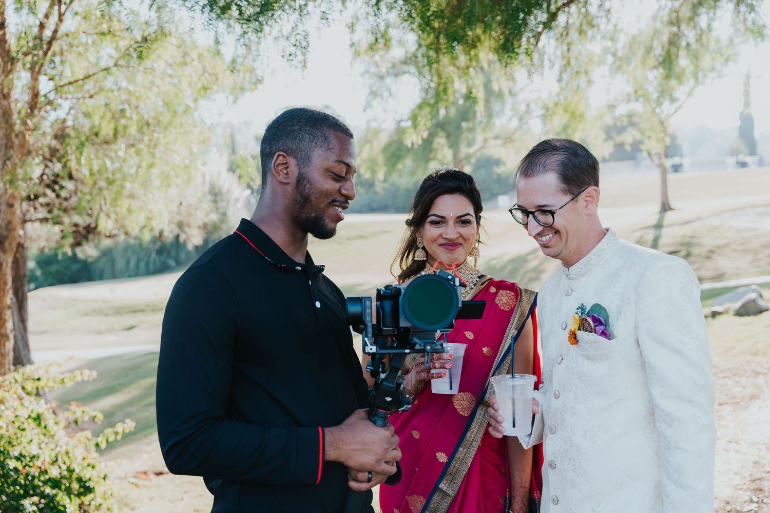 Three people share a candid moment during an outdoor celebration.