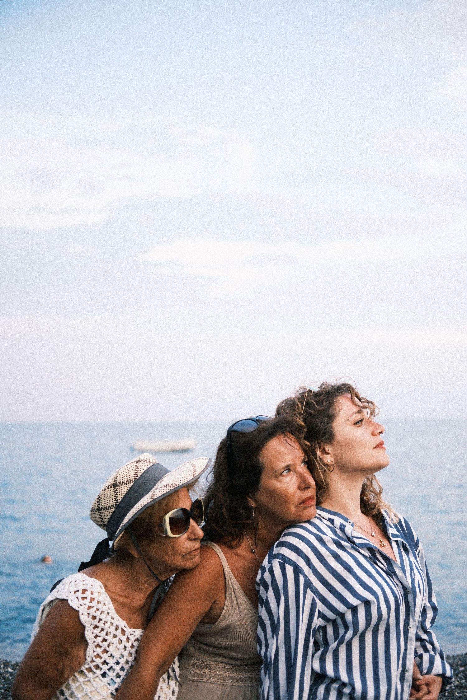Group of friends enjoying a sunny day outdoors wearing sunglasses and summer attire.