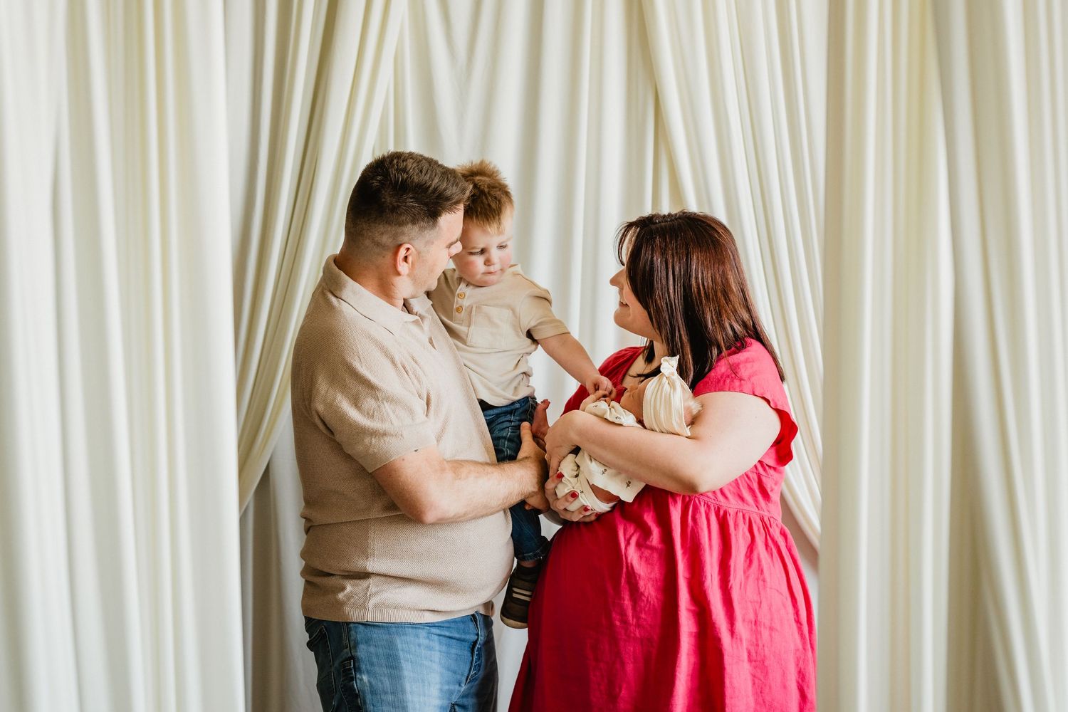 Ben + Ashley hold their toddler son and newborn baby girl.