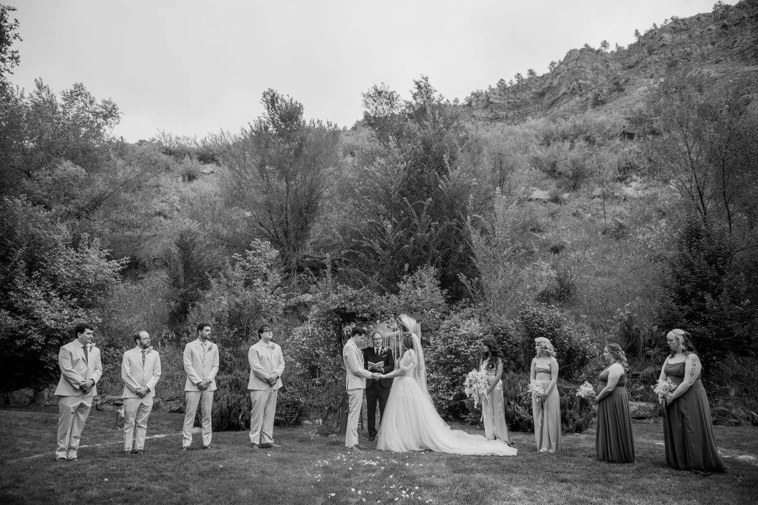A black and white photo collage shows figures in formal attire lining up outdoors against a natural backdrop.