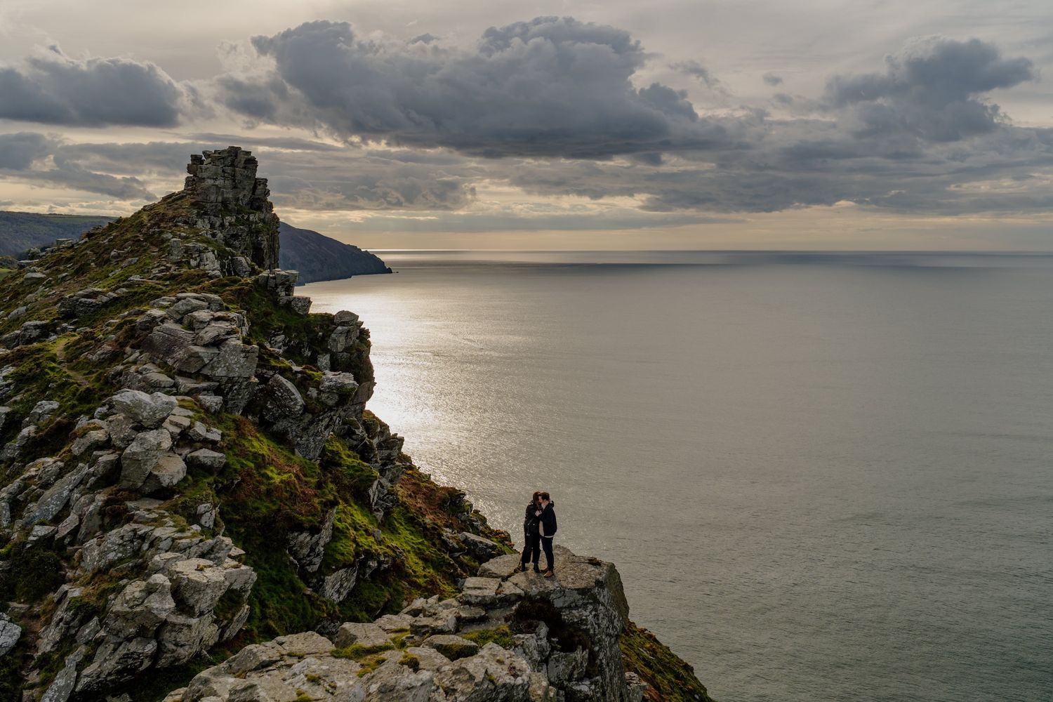 Couple walking on coastal path at the Valley of the Rocks during North Devon engagement shoot