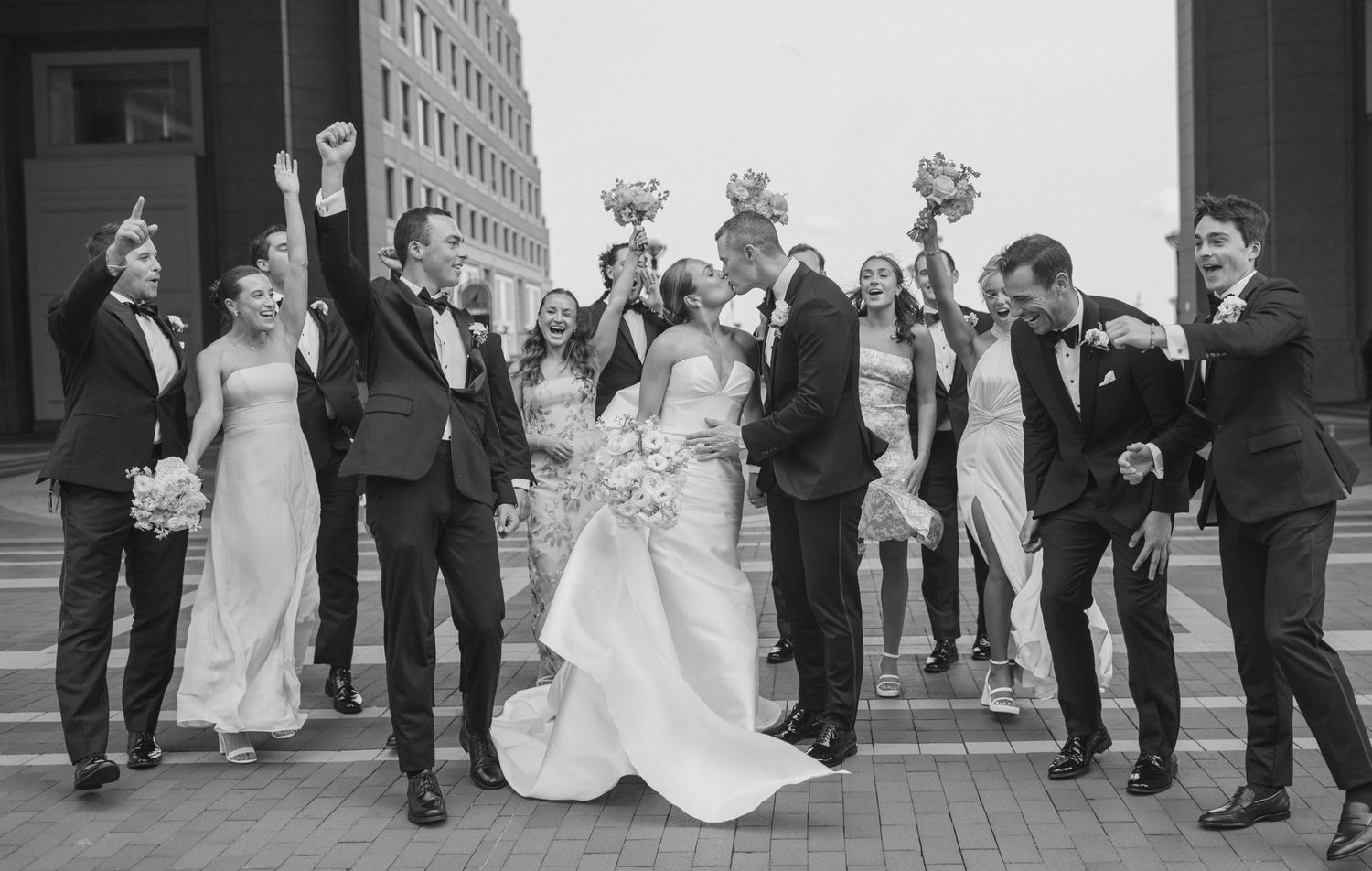 A romantic wedding dip kiss sequence on a brick courtyard with American flags in the background.