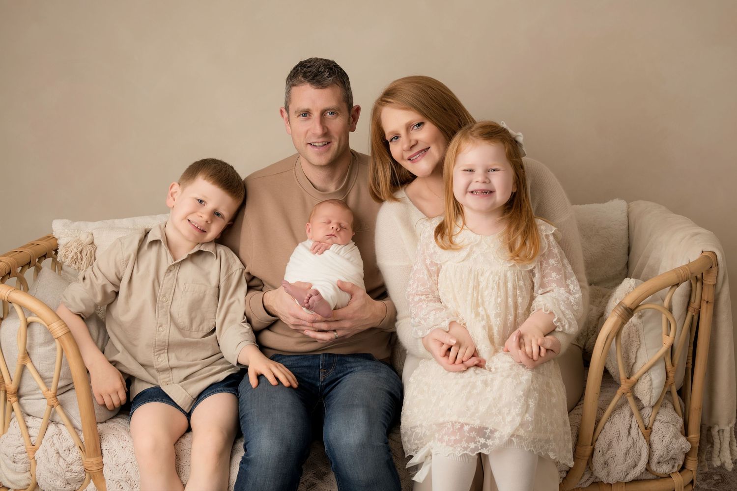 A series of family portraits in neutral tones showing parents and children sitting together in coordinated outfits.