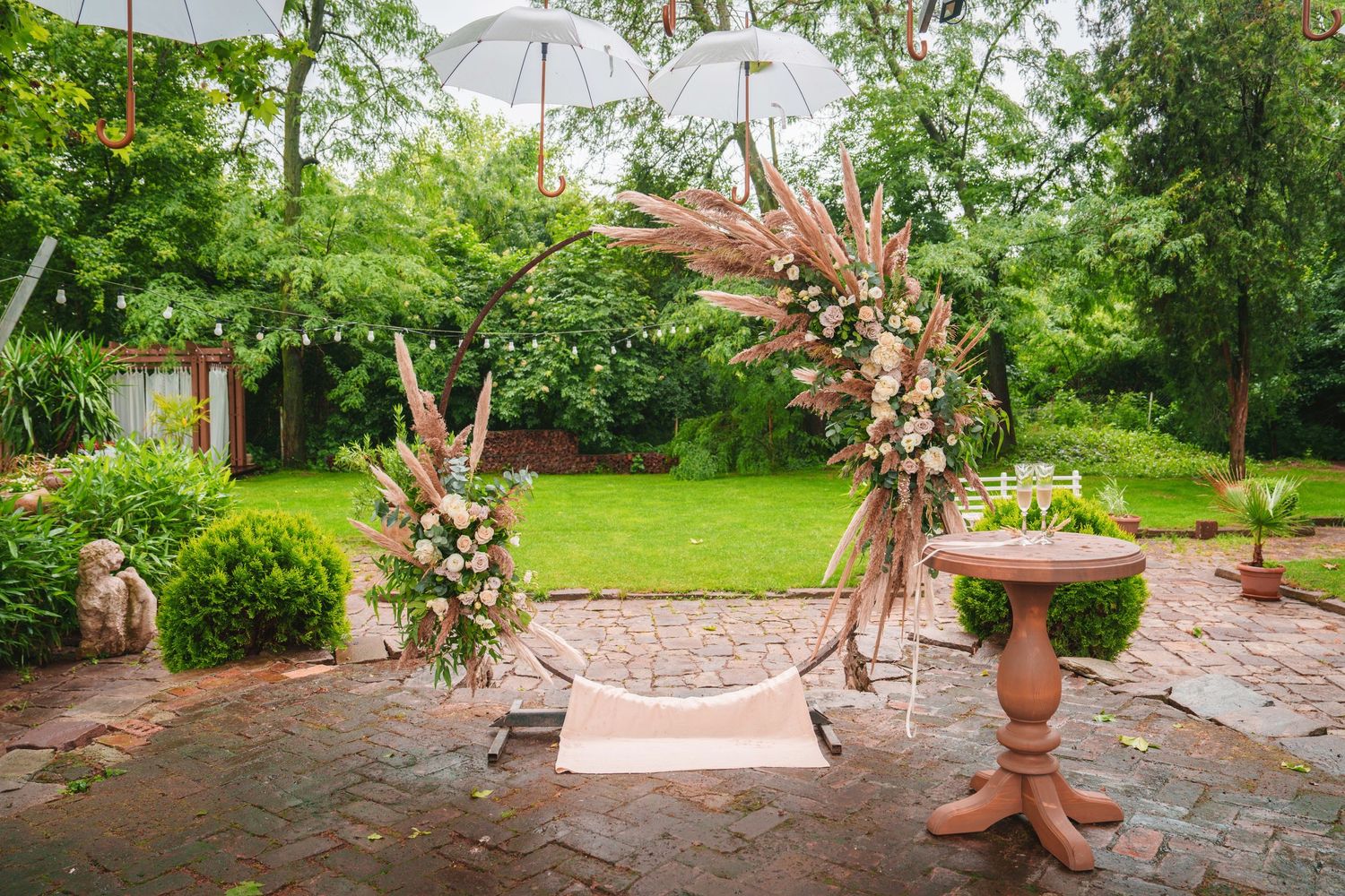 Joyful wedding guests and newlyweds celebrate with raised arms during an outdoor reception ceremony.