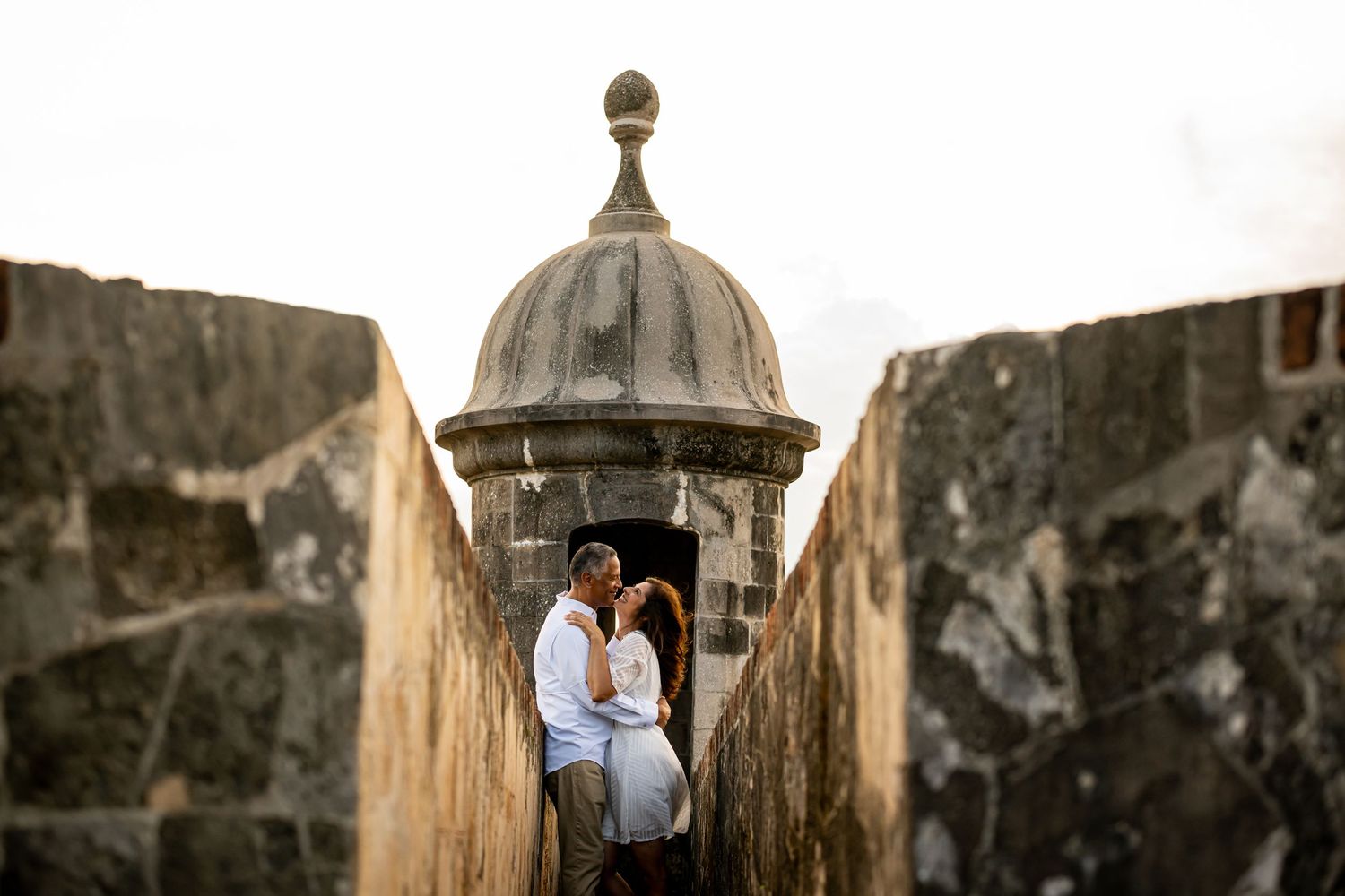 Romantic silhouette of couple in historic stone fortress lookout point.