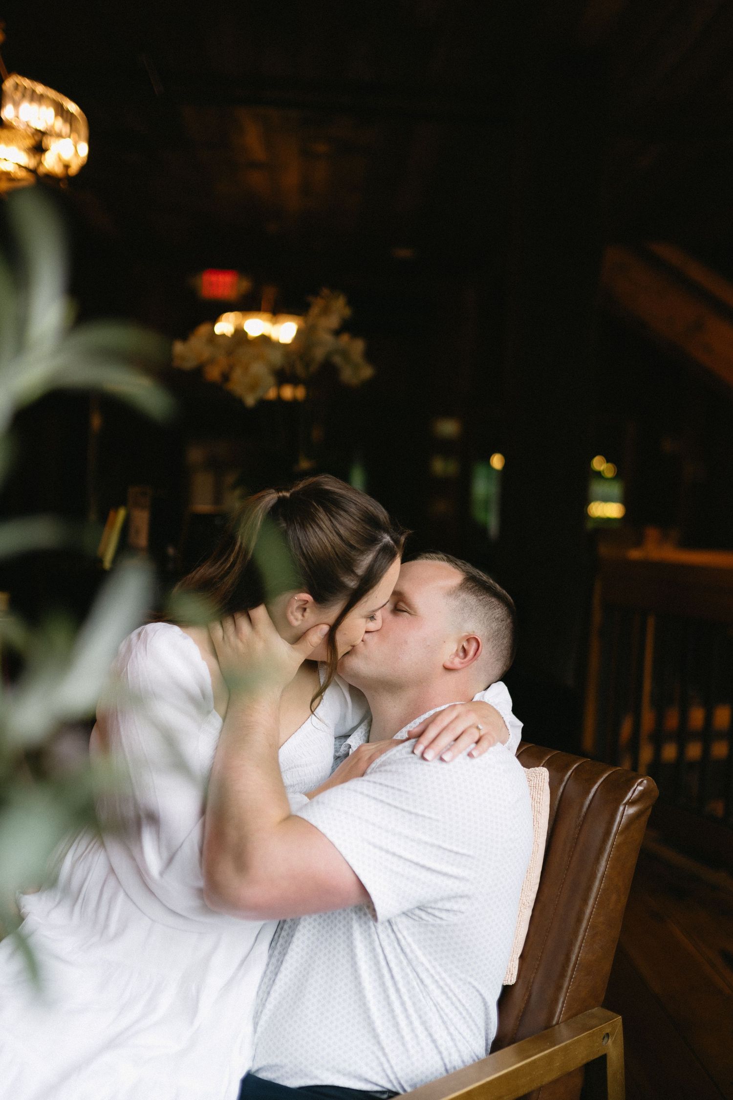 Romantic black and white photograph of a couple embracing on a wooden porch at sunset.