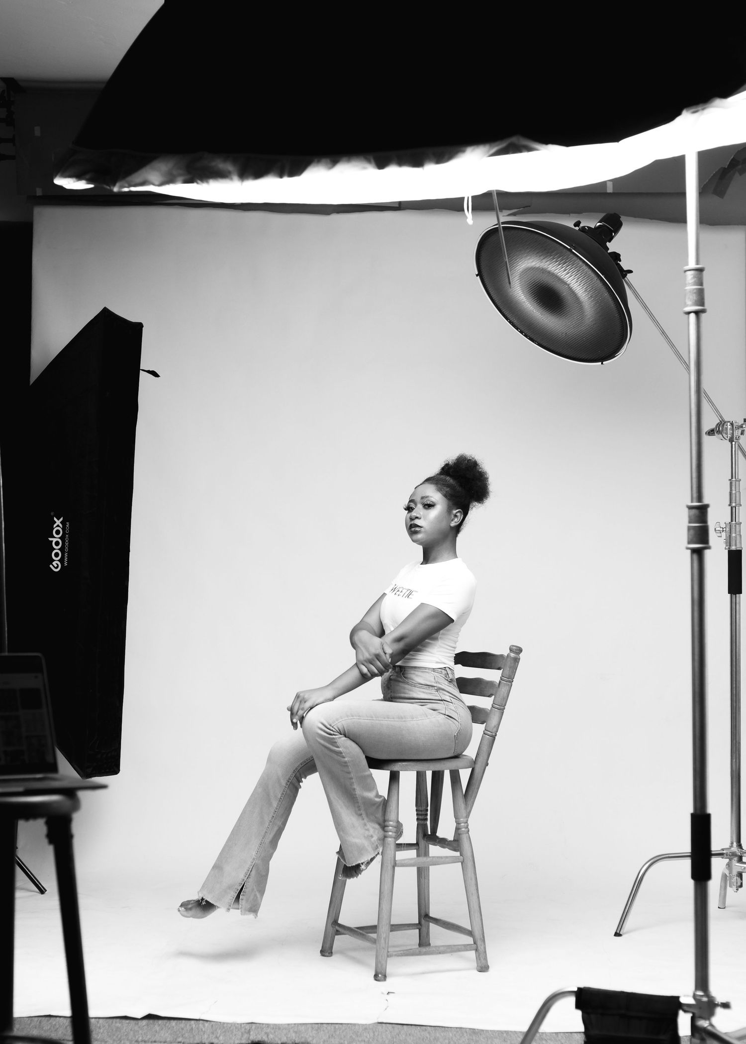 Person wearing a grey button-up uniform-style shirt with matching pants stands against white backdrop in photo studio setting.