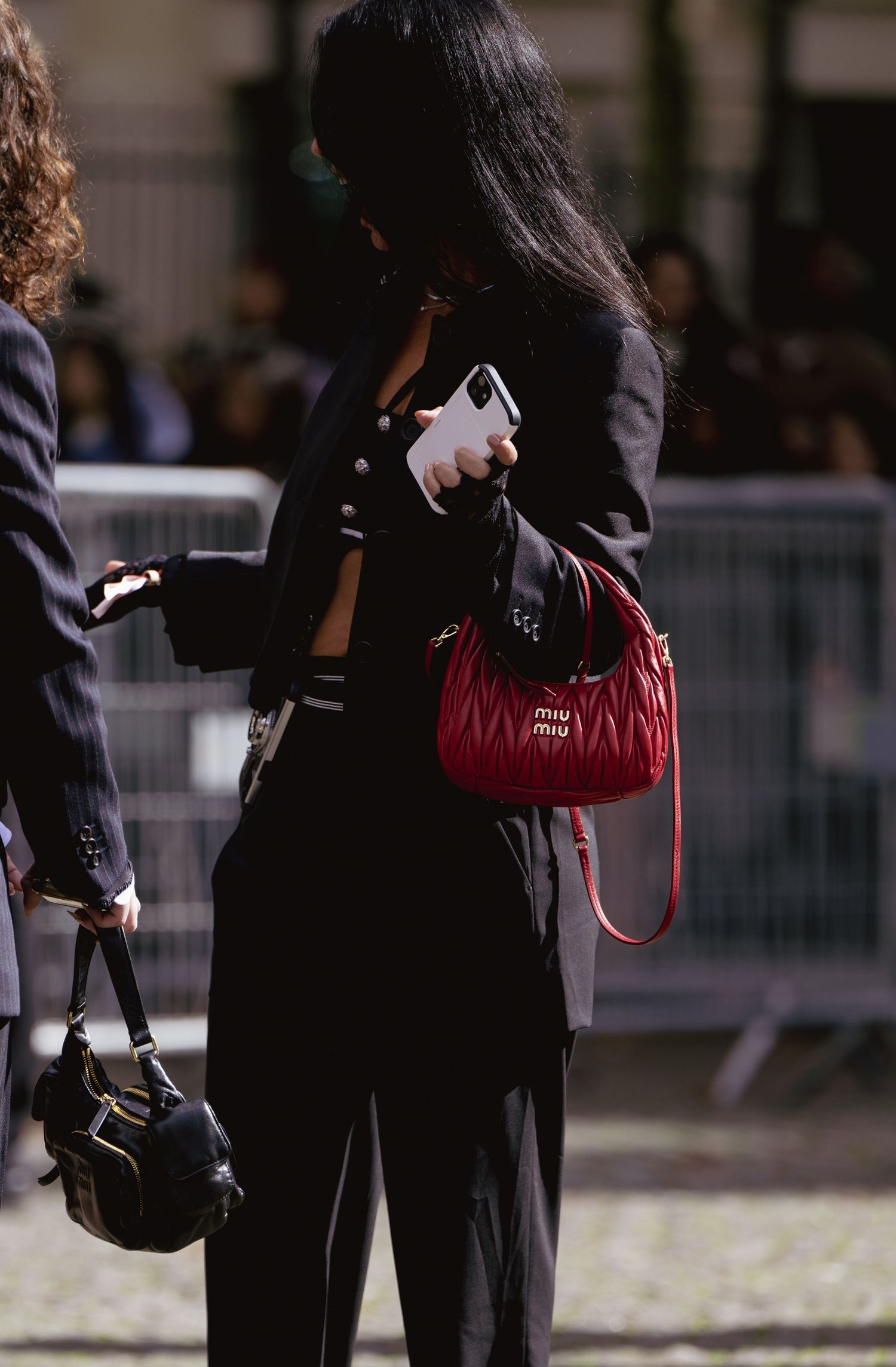 Street style snapshot featuring black outfit with red designer handbag.