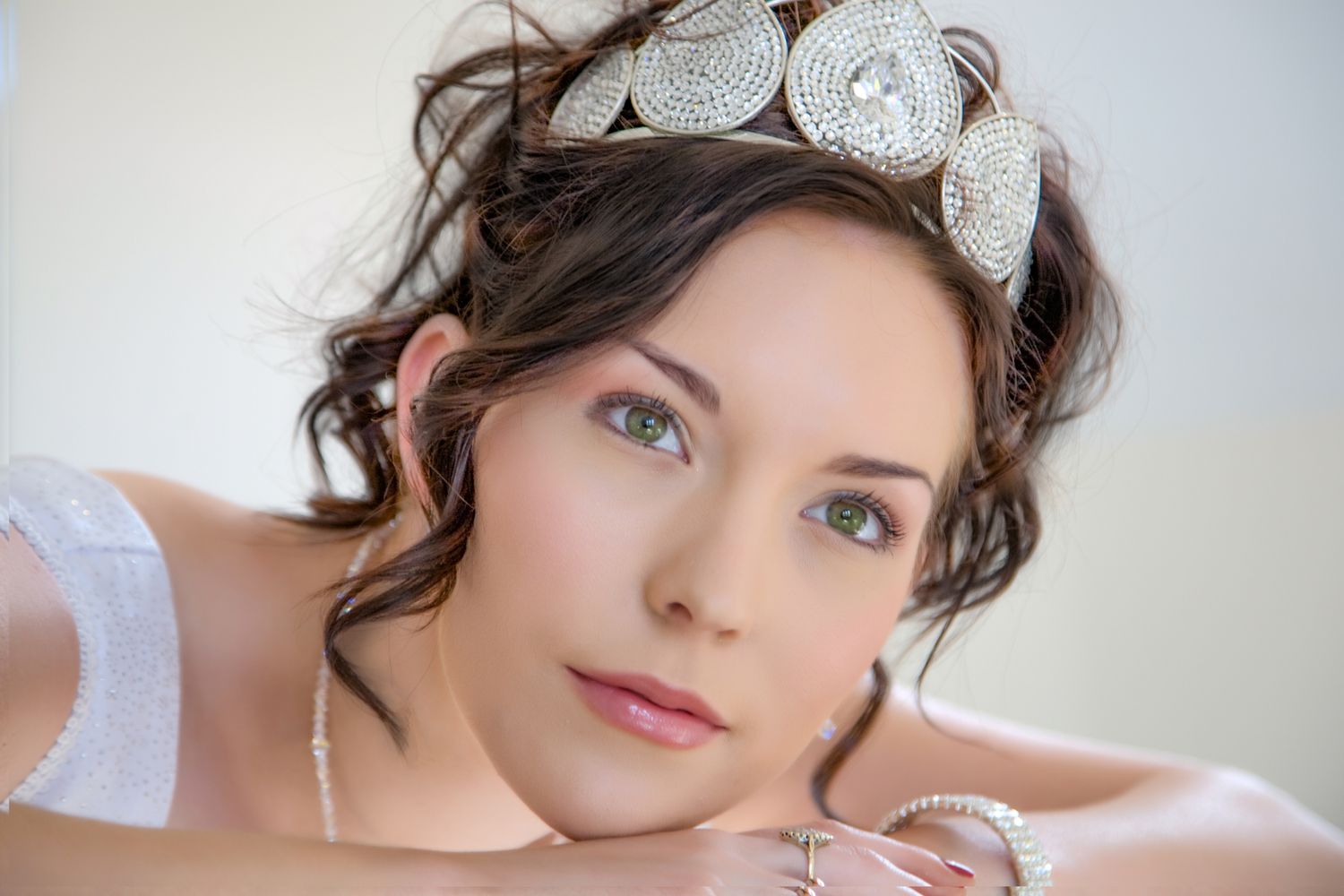 Elegant bridal portrait featuring delicate crystal headpiece and soft romantic styling.