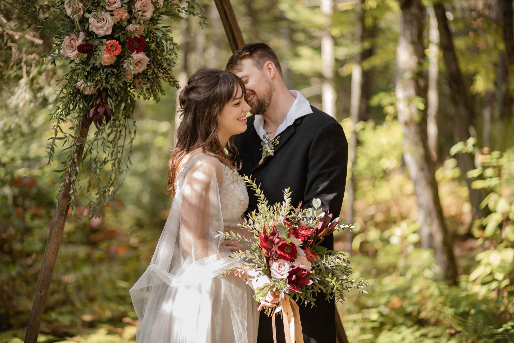 Eloping couple stands at a wooden arch during their ceremony. Lumenali Photography.