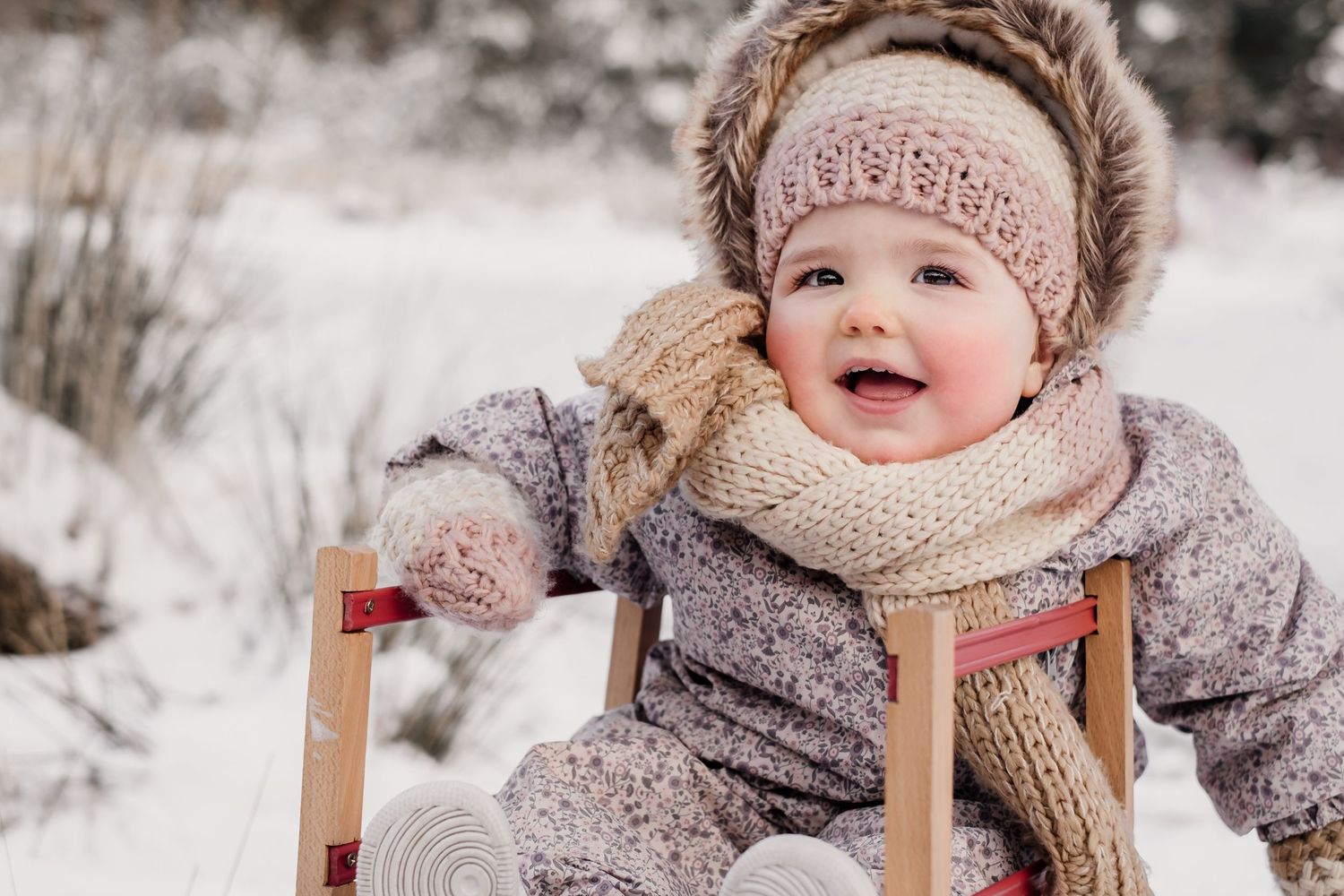 Meisje op een slee tijdens een winterse fotoshoot in de sneeuw, vastgelegd door een lifestyle fotograaf in Geldrop. Pure plezier te zien.