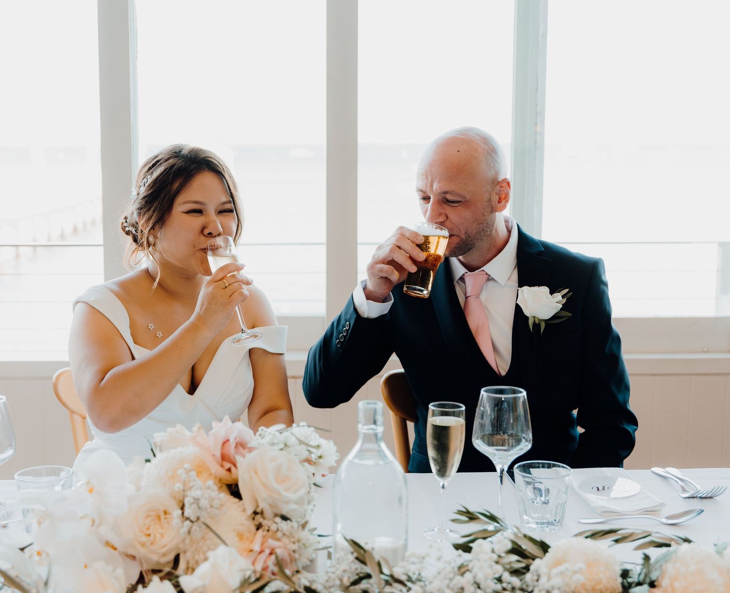 A series of elegant wedding reception photos showing candid moments between people at a white-decorated dining table.