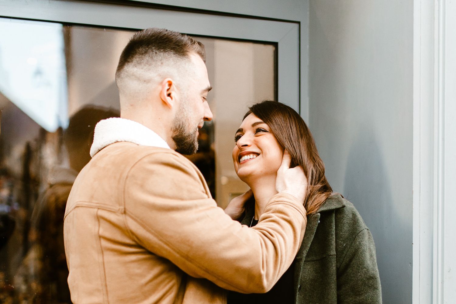 Couple en train de rire et de s'embrasser devant une devanture de fleuriste pour la saint valentin