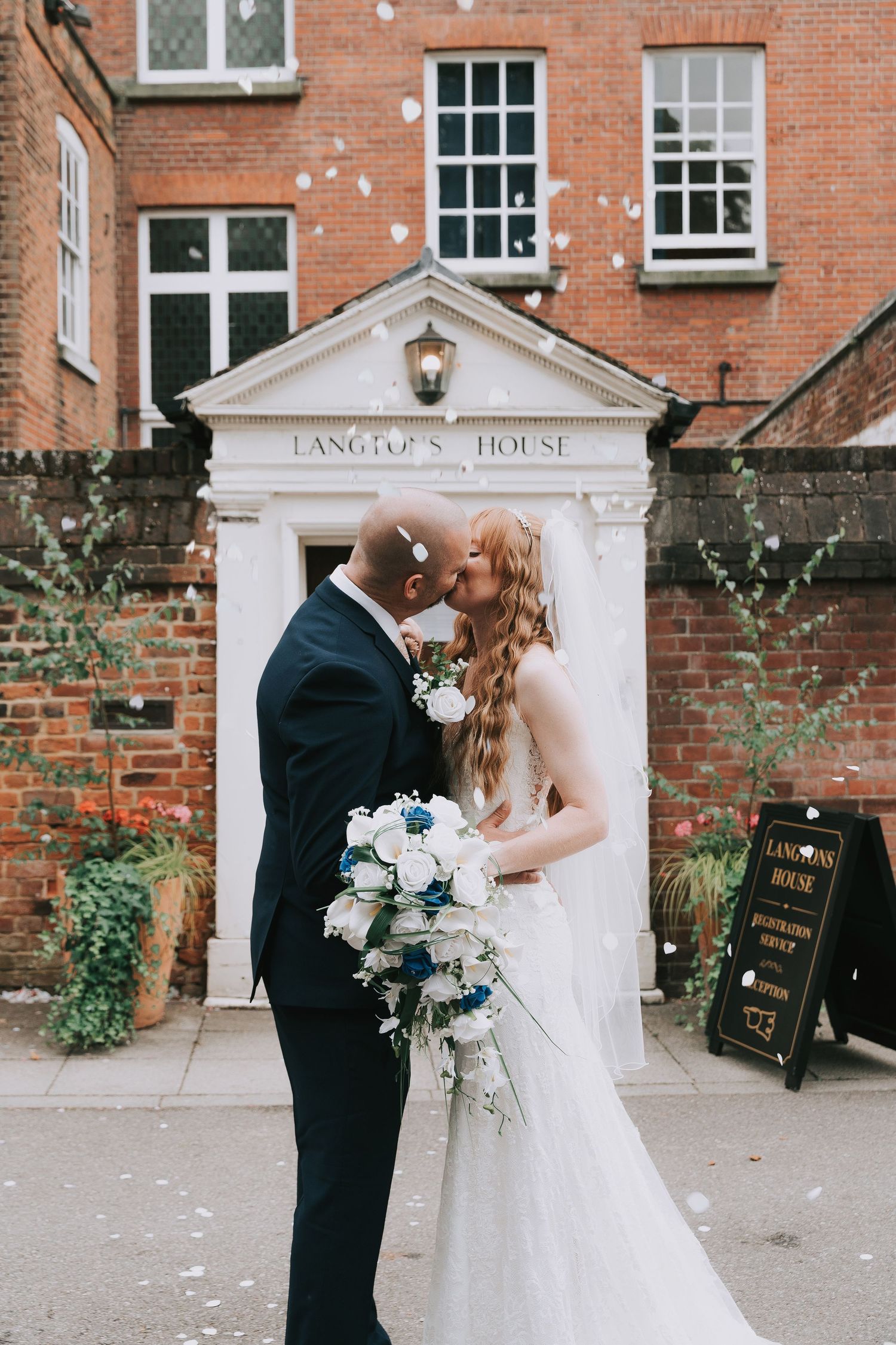 Romantic wedding couple shares intimate moments against rustic brick wall backdrop at historic Langton's House Registry Office