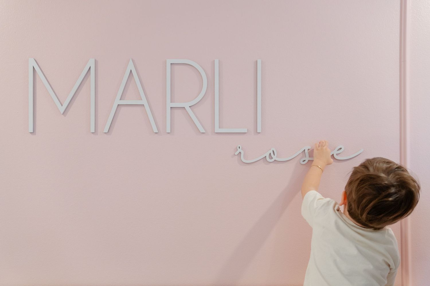 A pink storefront window display with modern minimalist design and soft lighting.