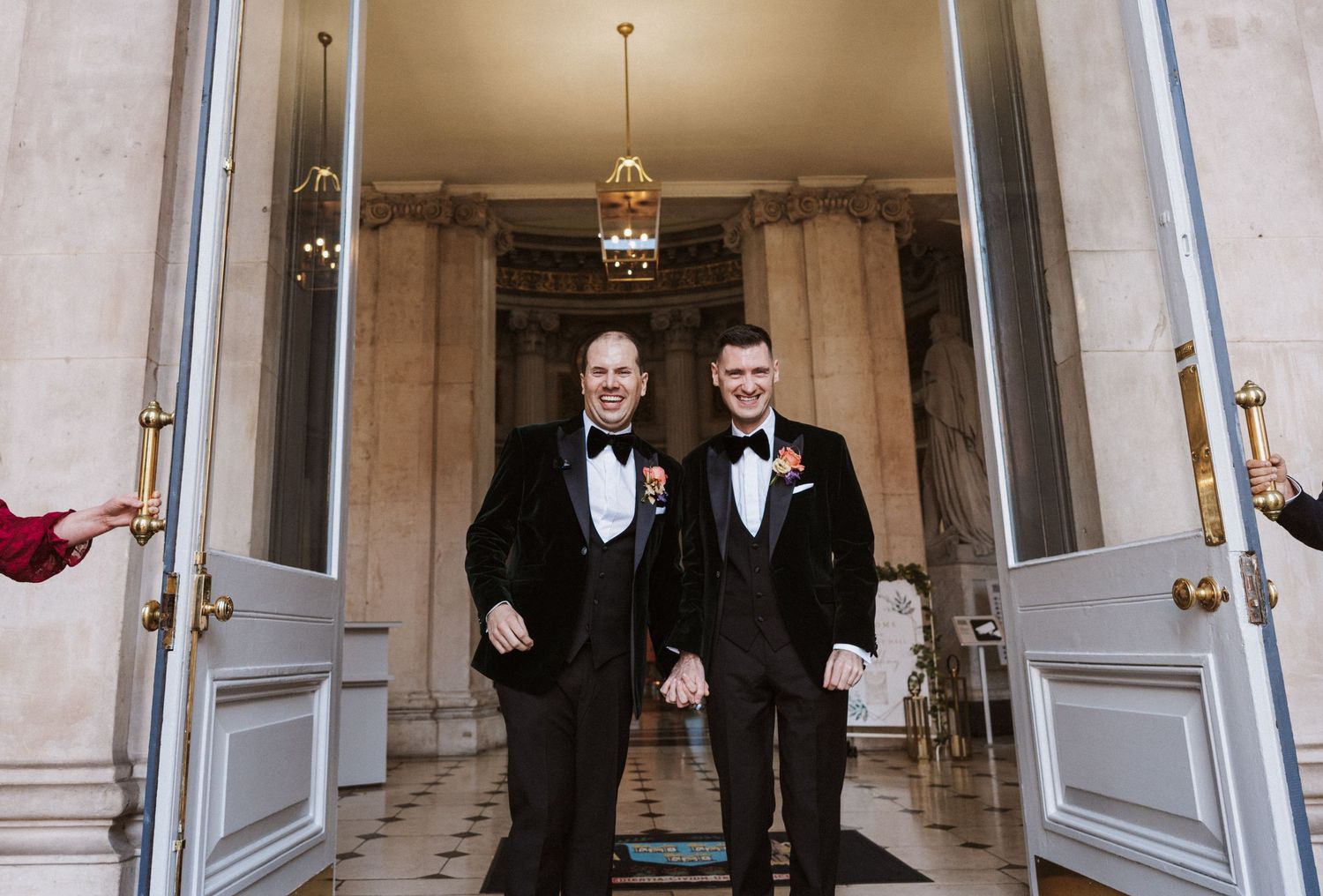 A black and white photo series showing two people in suits interacting and laughing together in formal settings.