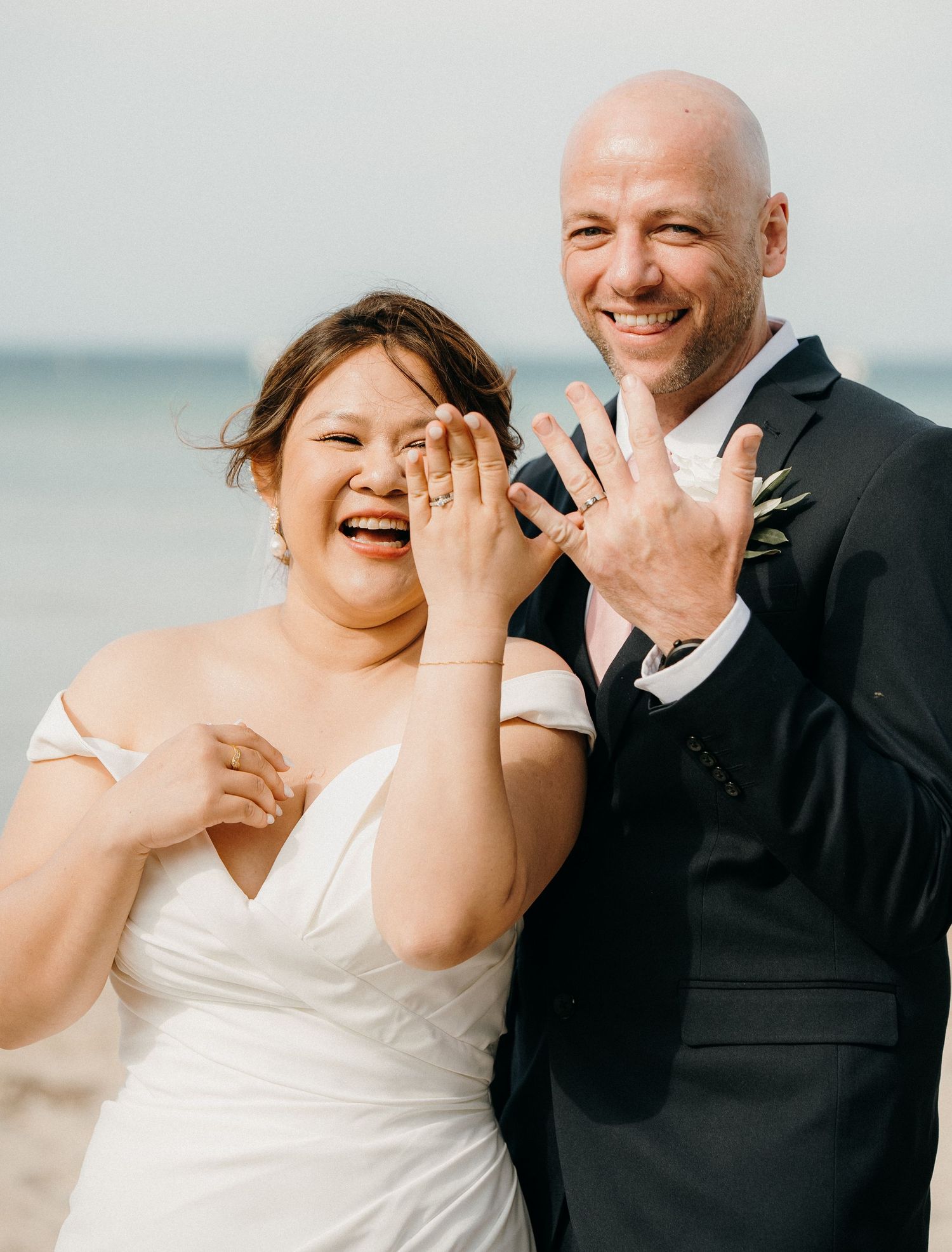 A joyful wedding couple laughs together during a sequence of candid beach photos in natural lighting.