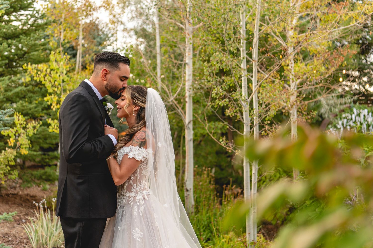A series of romantic outdoor wedding photos showing the couple in different embraces among trees and autumn foliage.