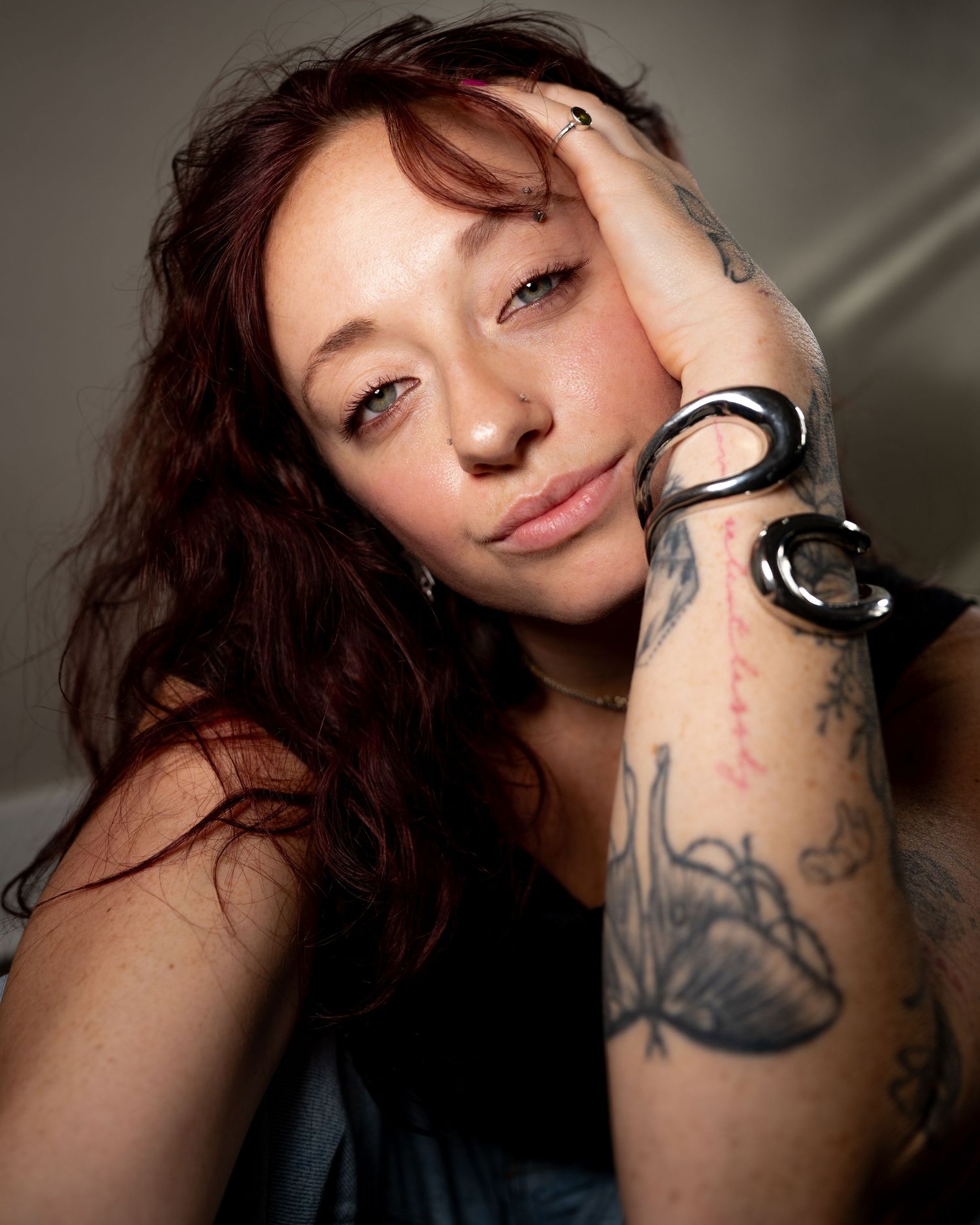 A series of close-up portrait photos showing dark hair and tattoos on skin in moody lighting.