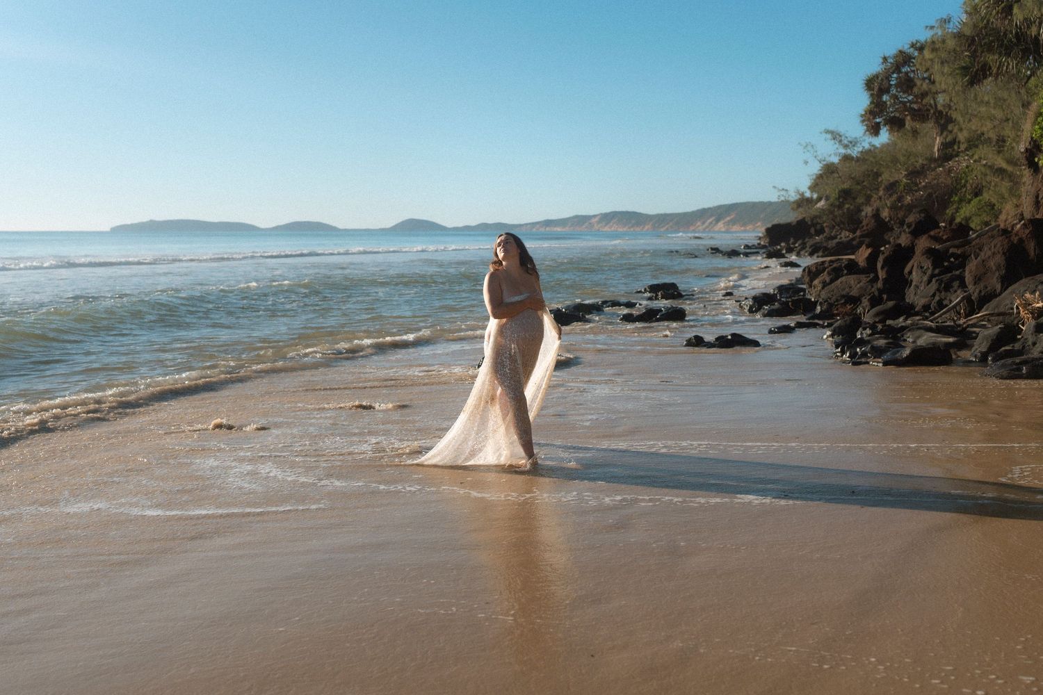 A series of coastal beach photos showing sandy shores, gentle waves, and distant mountains along a tranquil shoreline.