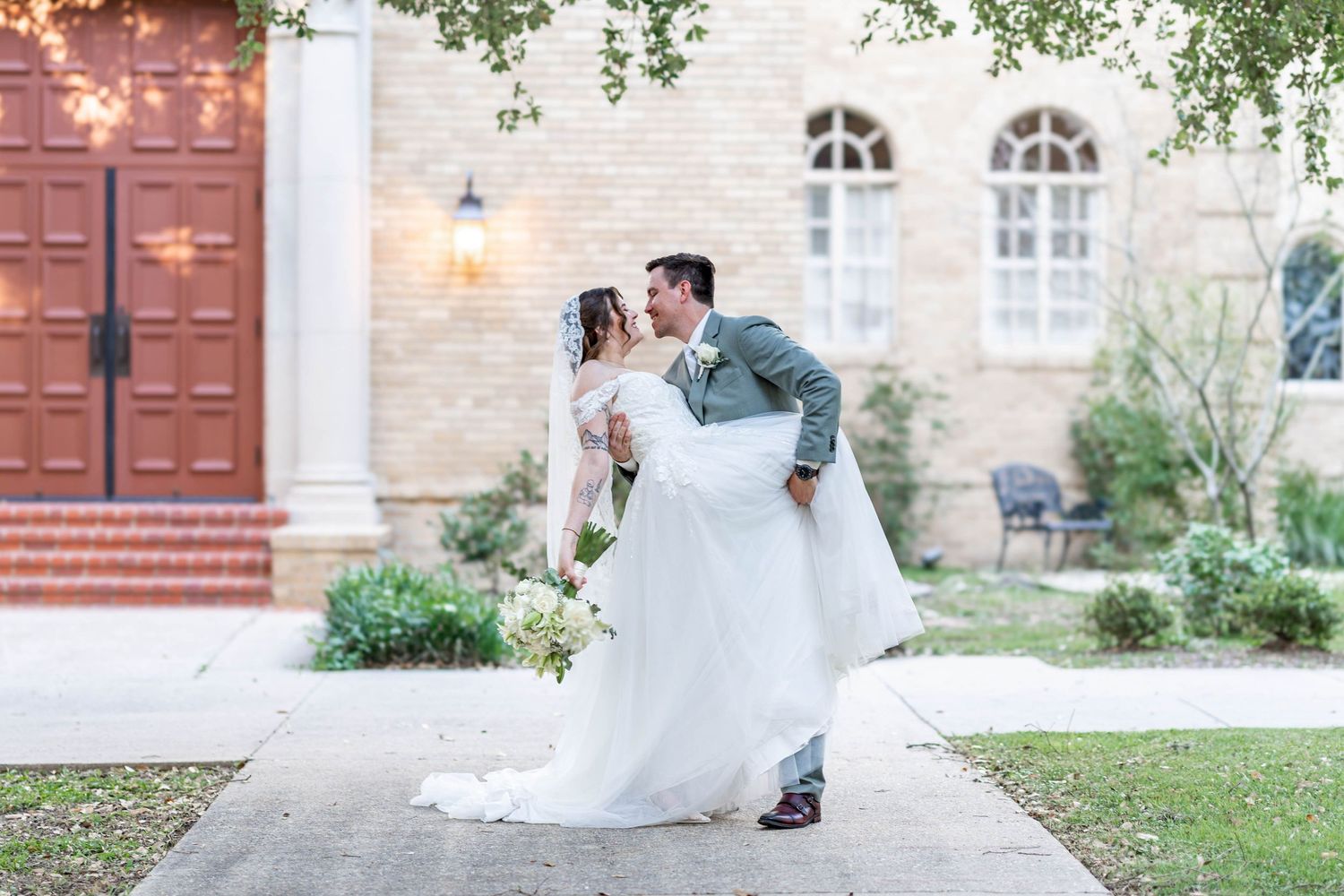 groom dips bride at christ the king Catholic Church on LSU campus