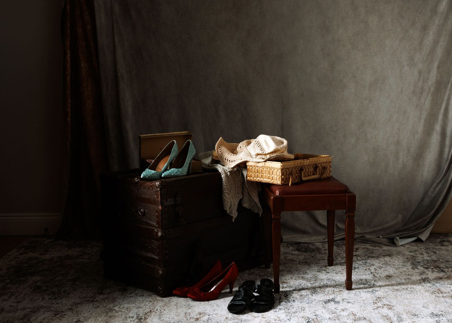 Gold Elite chocolate box surrounded by colorful beaded necklaces, handbag, and heeled sandals on a patterned rug in Truro N.S. photo studio.