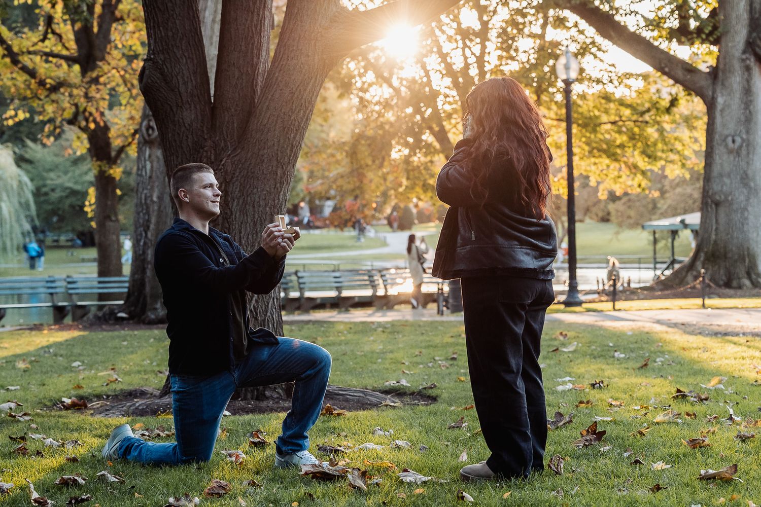Romantic autumn proposal in park during golden hour.