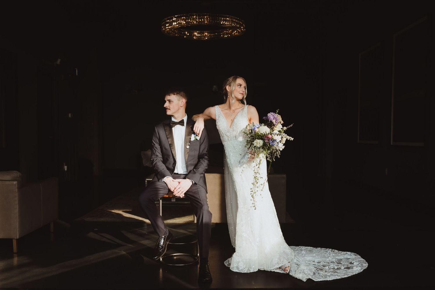 Wedding photography in low light featuring elegant white gowns and floral arrangements.