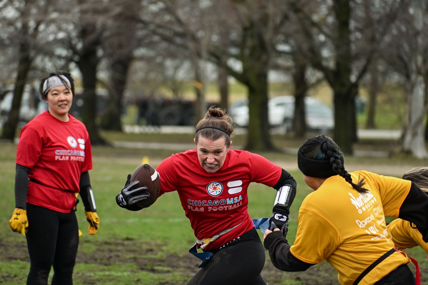 A football player runs forward with the ball while an opponent attempts to stop the drive