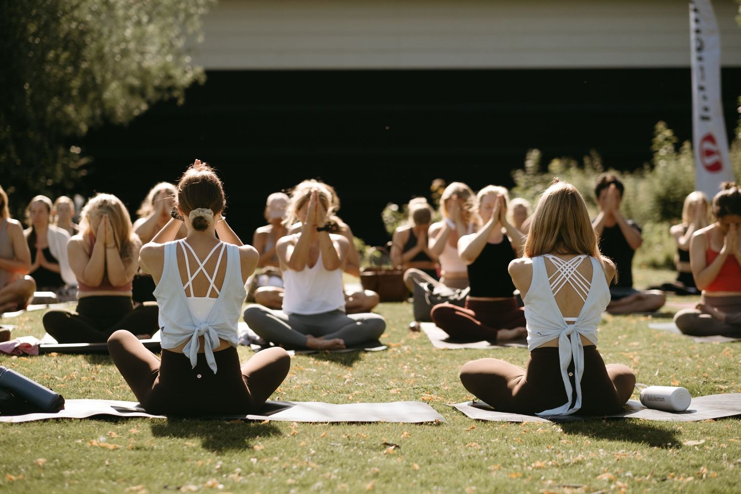 a group of people practising yoga together at Djurgården while being captured by yoga photographer in Stockholm