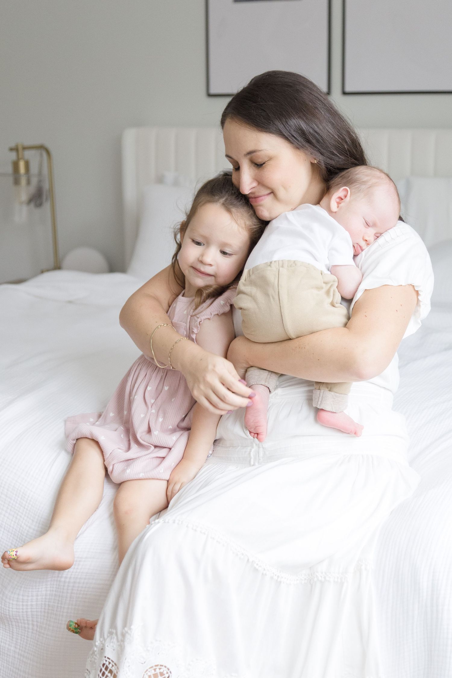 A mother cuddling her babies in an in-home lifestyle newborn session in Washington DC