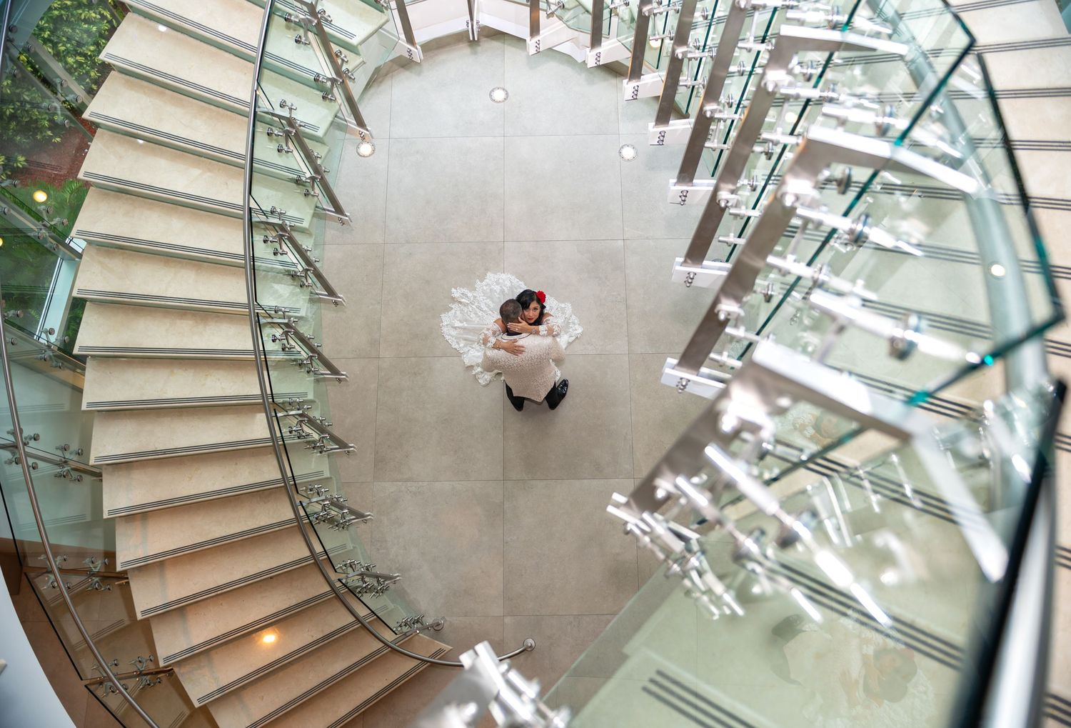The groom holds his bride as she looks up the stairs into the lens of the top South Florida wedding photographers.