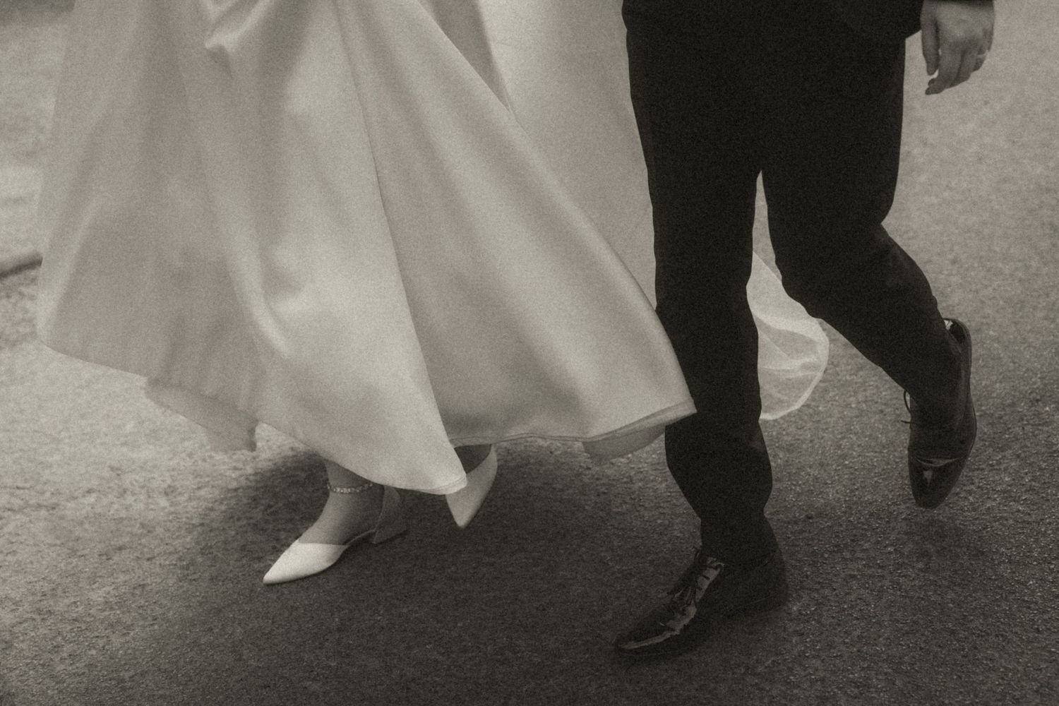 Romantic close-up shot of newlyweds embracing through a delicate white veil against a dark background.