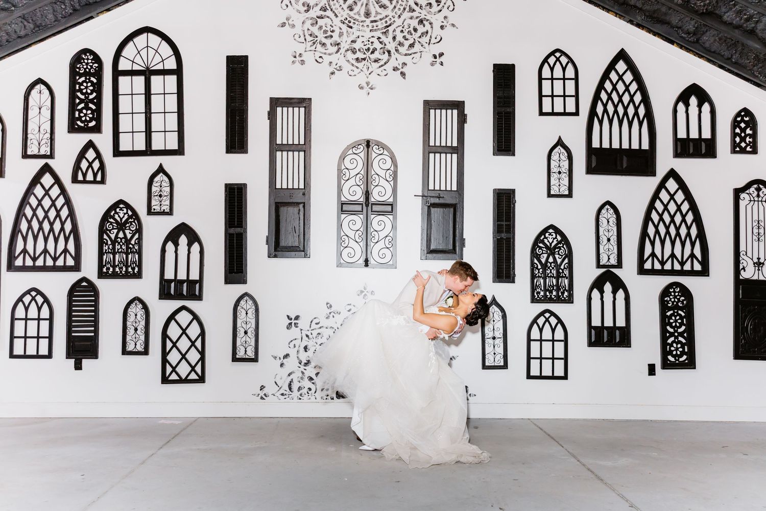 Black and white hand-drawn window pattern illustrations line a white wall in an architectural installation.