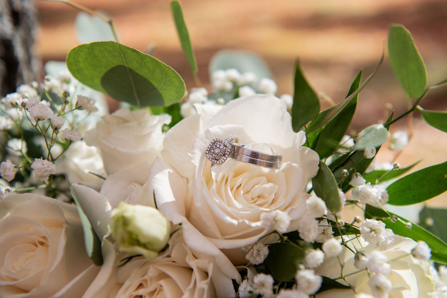 A close-up view of delicate white roses and baby's breath flowers arranged in an elegant wedding bouquet.