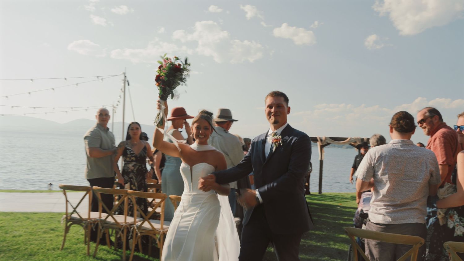 Panoramic collage of an outdoor wedding ceremony on a grassy field with guests seated in white chairs under blue skies.