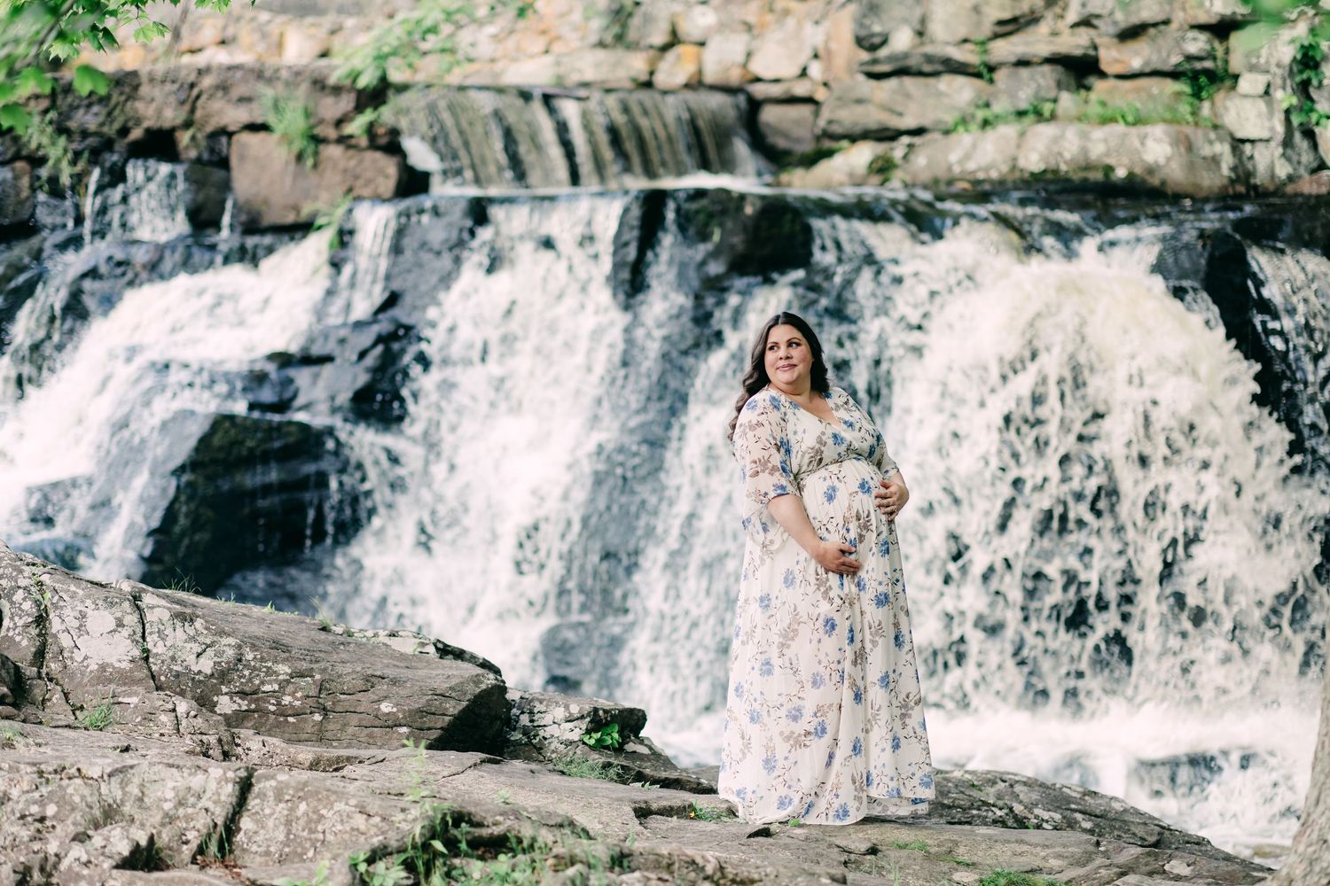 A beautiful pregnant mama during her maternity shoot in front of the waterfall at Southford Falls