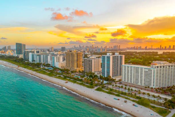 Aerial view of Miami Beach coastline with high-rises during golden sunset.