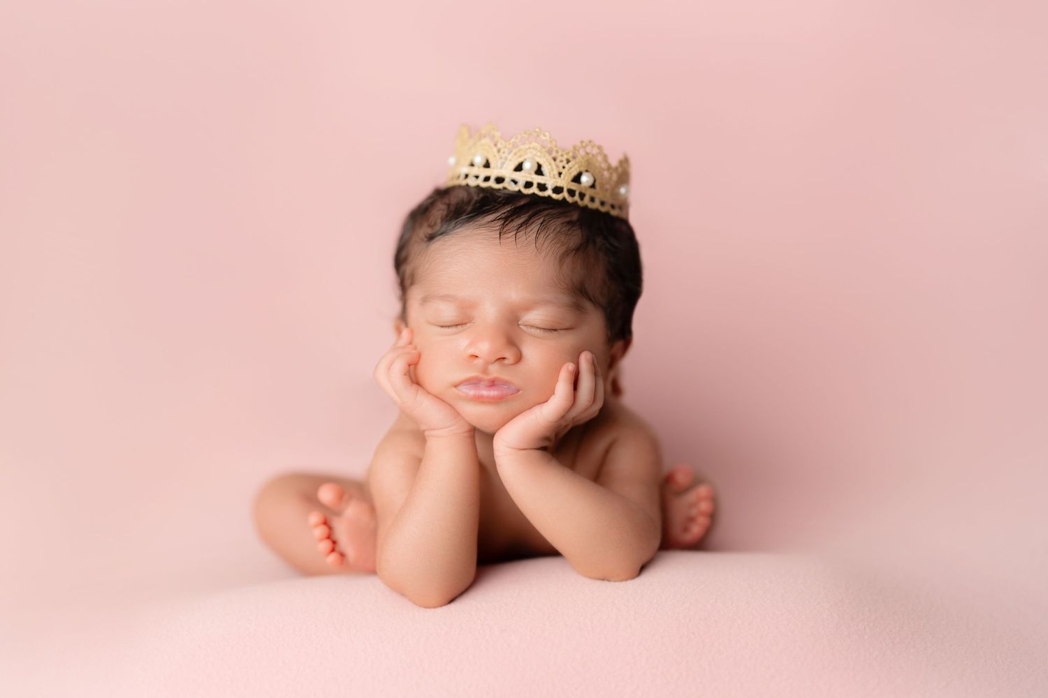 A princess in a froggy pose on pastel pink background