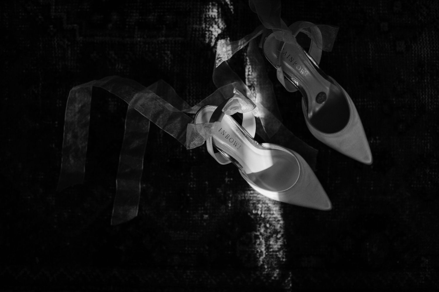 Artistic black and white photograph of smoke curling and twisting against a dark background creating abstract patterns.