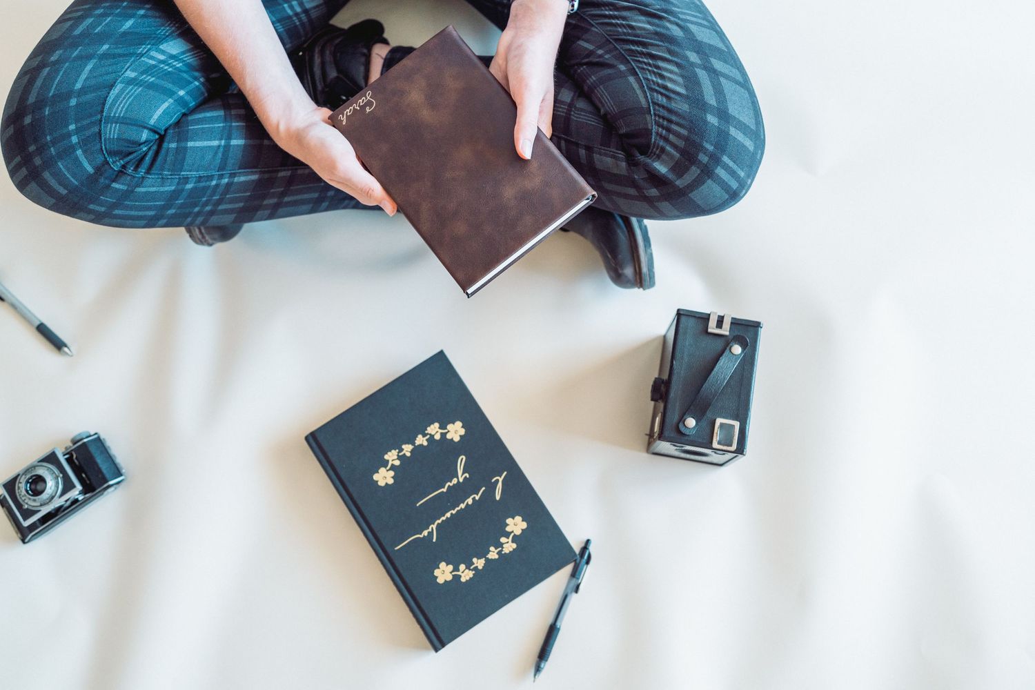 Cameras, books, and pens on ground around woman at branding session in Phoenix, Arizona