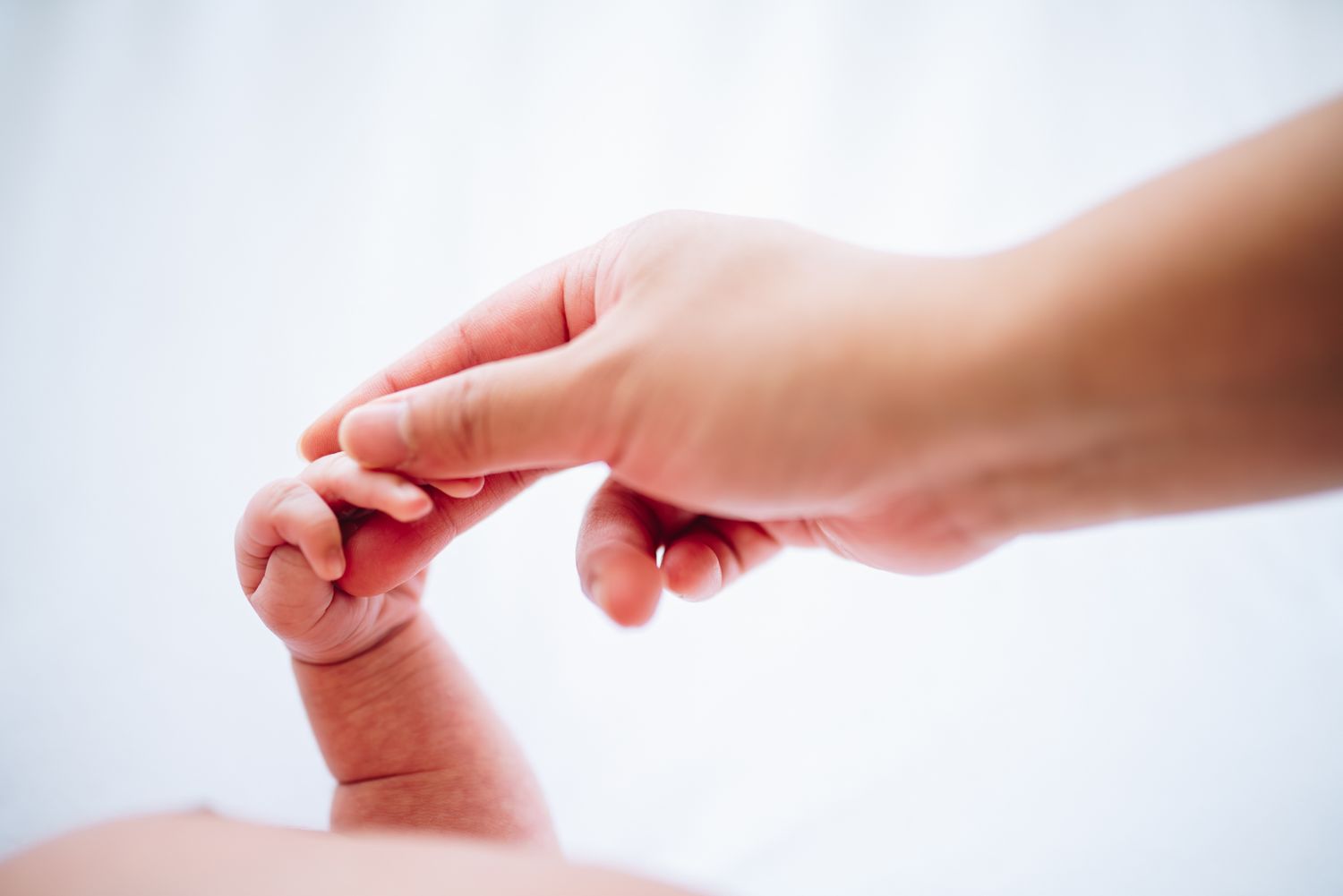 Mom holding her newborn's finger during a newborn and family photo session in Melbourne by newborn, maternity and family photographer Pei A