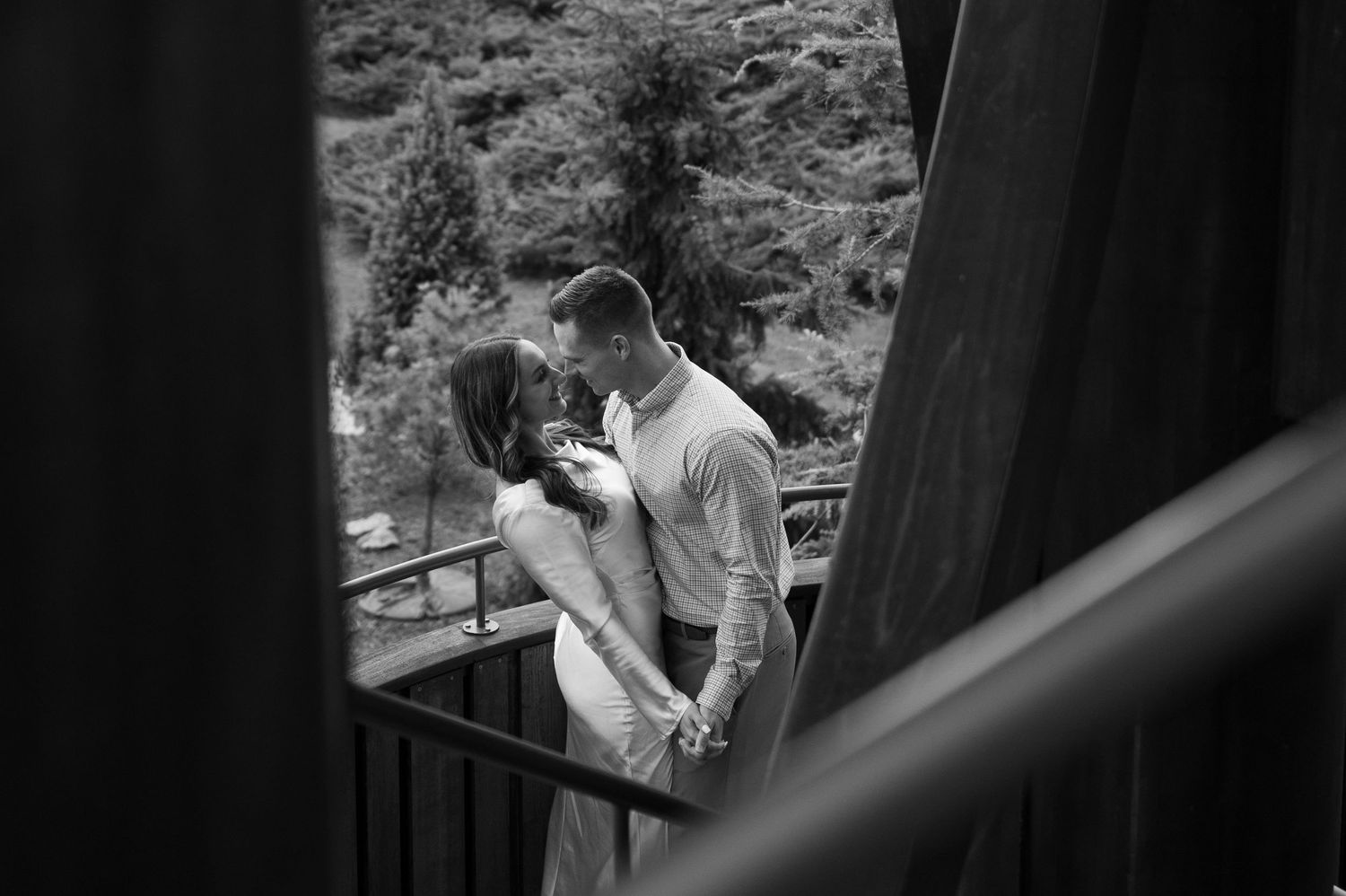Romantic couple leaning against brick wall in urban setting.