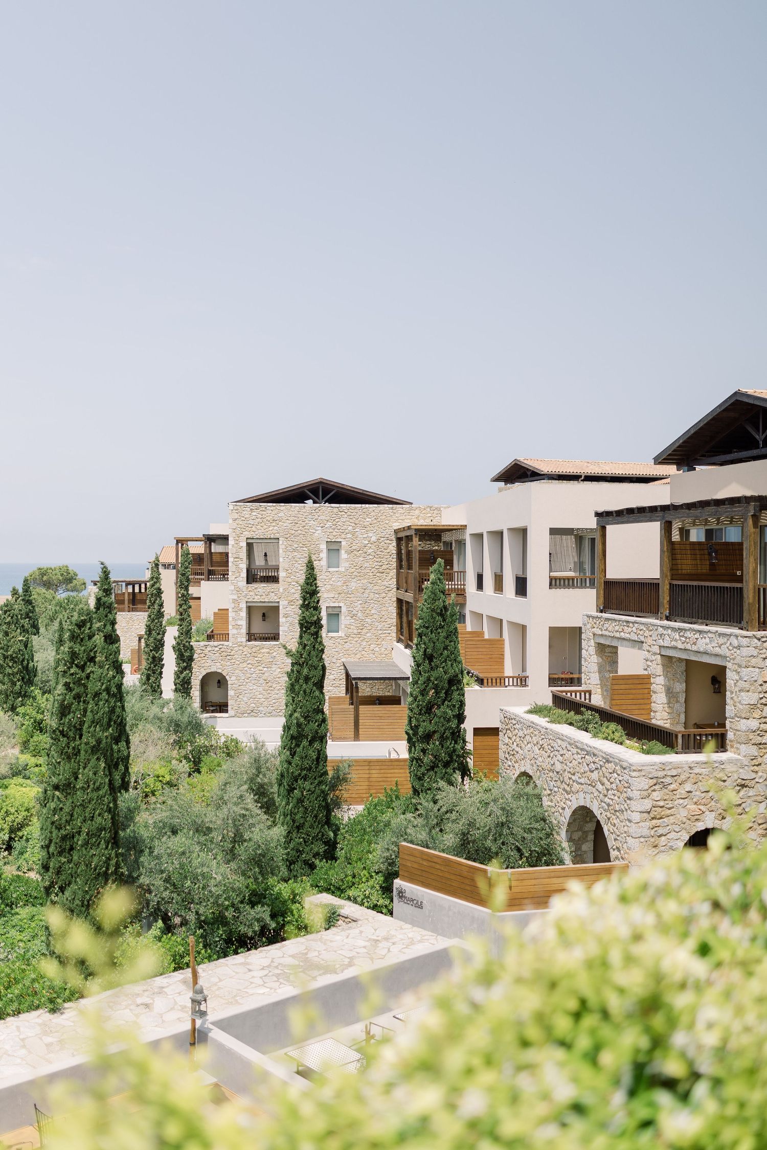 Mediterranean-style stone buildings with wooden balconies nestled on a hillside.