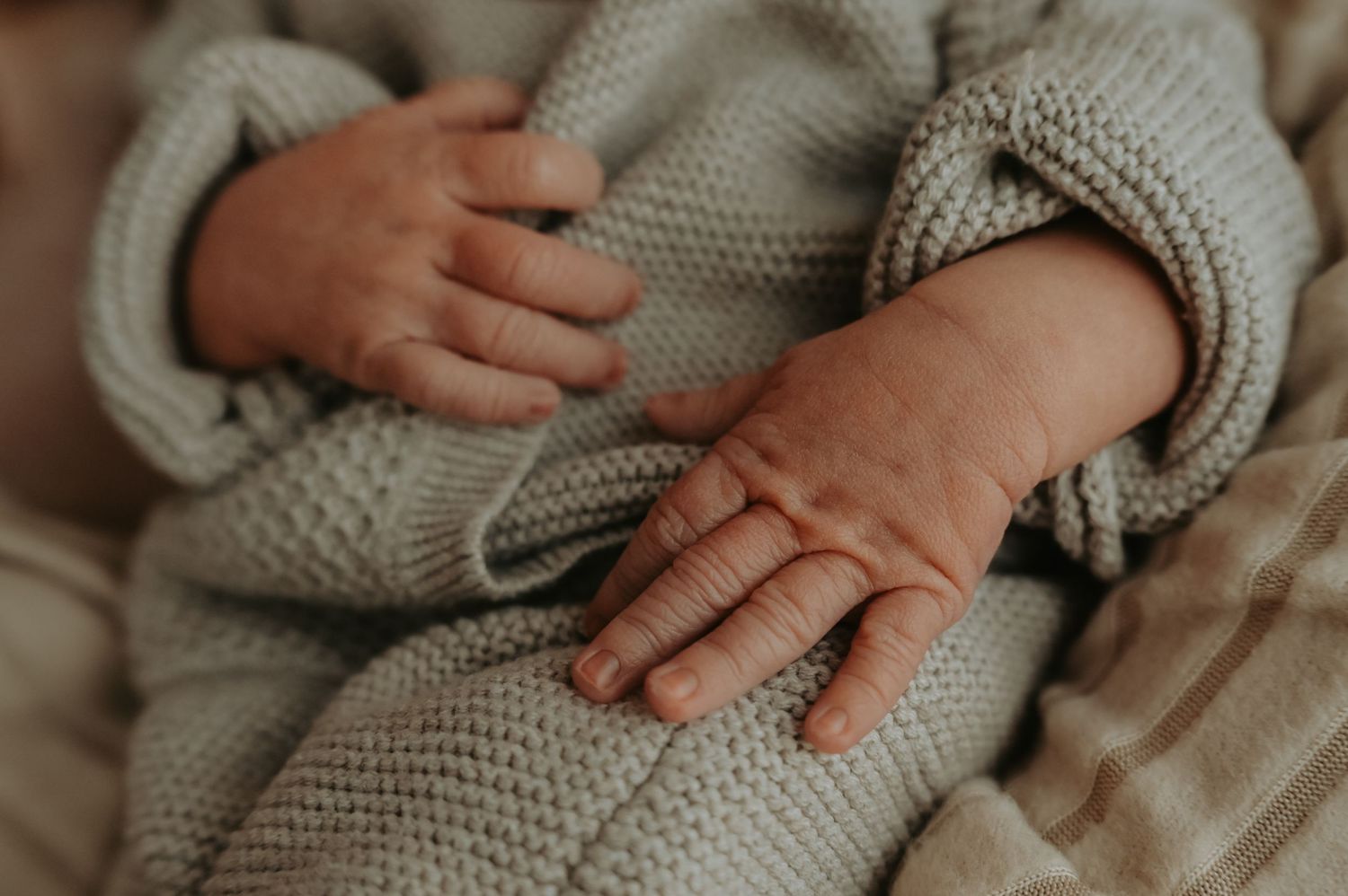 Newborn laying in fathers arms