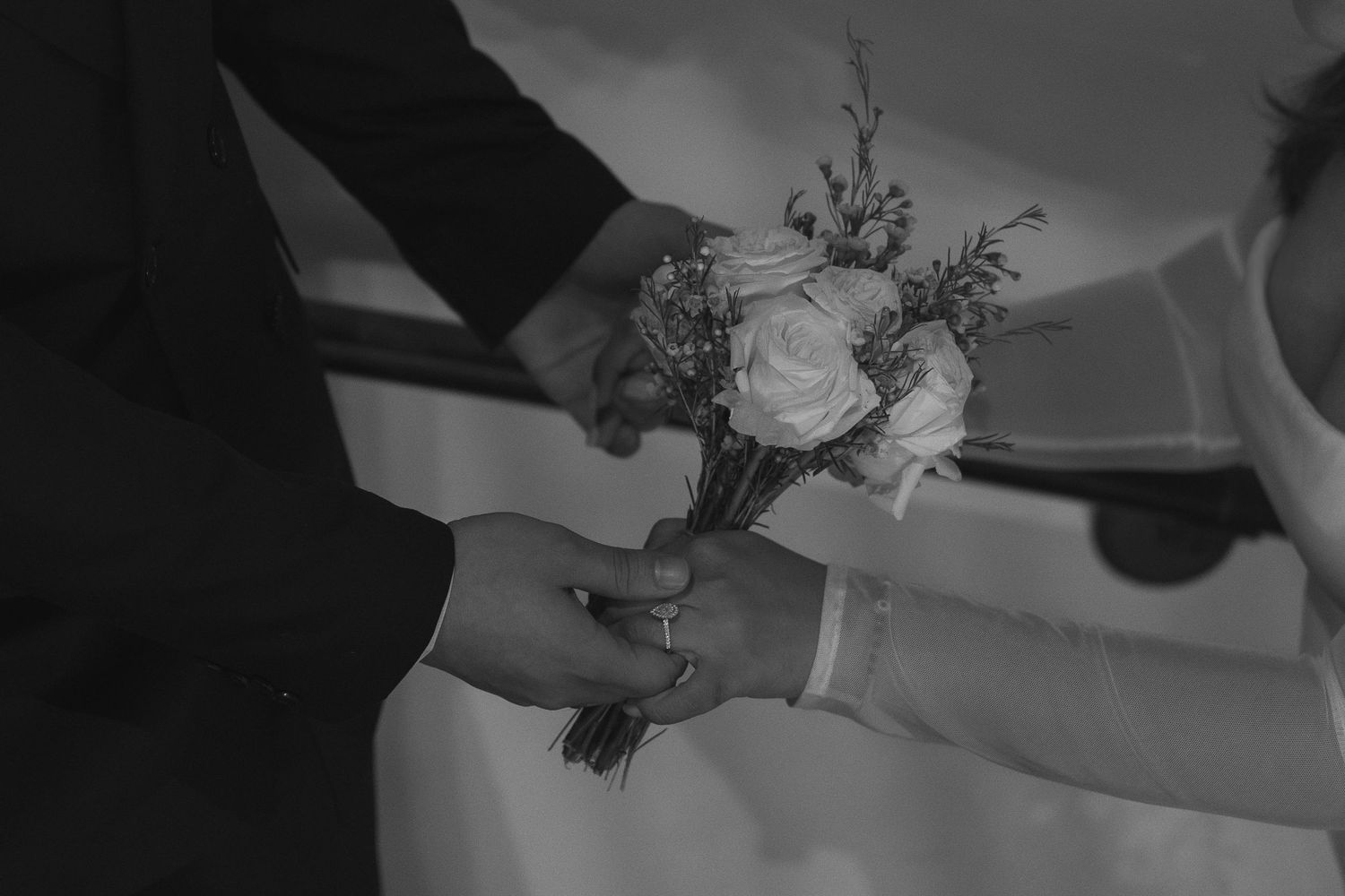 Elegant wedding ceremony with white floral arrangements and decorative arches in a romantic garden setting.