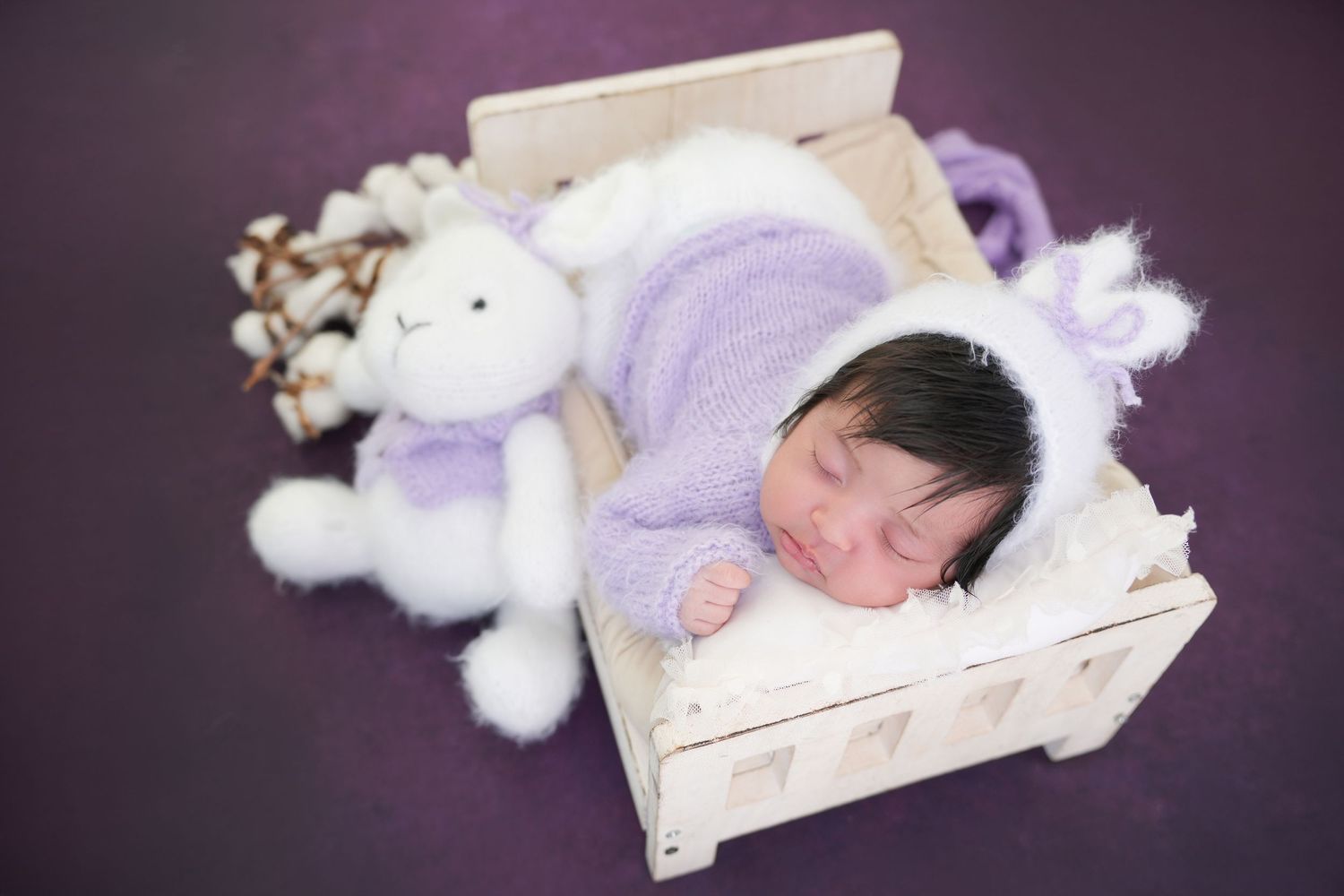 Newborn photography Dubai session with baby in minimalist setup, neutral tones, soft fabrics, and lifestyle posing in a professional studio