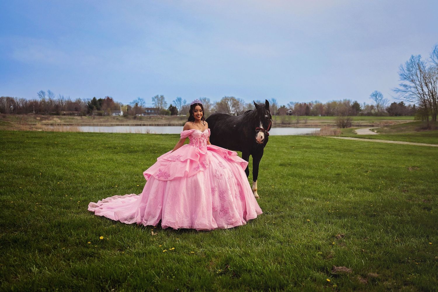 A flowing pink princess gown stands out against a scenic lake backdrop.