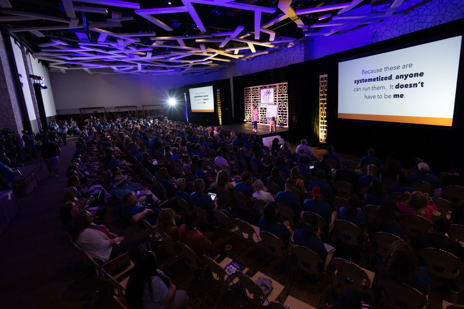 Large conference audience watches a keynote presentation on a big screen in a modern convention hall in Mexico with expert off camera flash