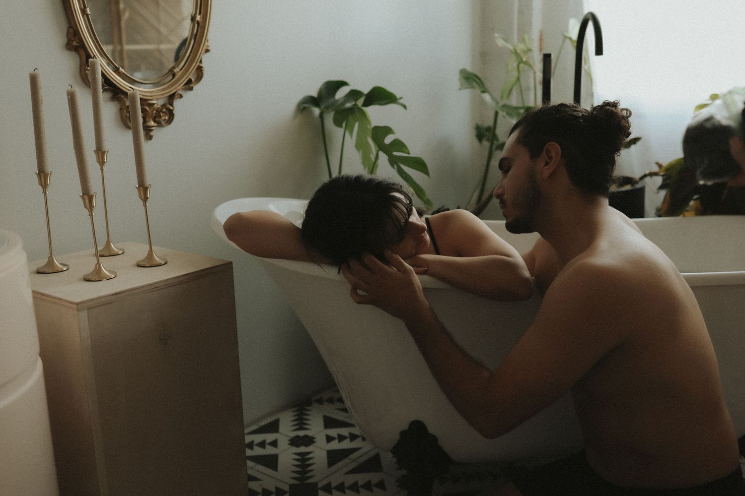 A series of intimate black and white photographs showing tender moments between two people in a domestic setting.